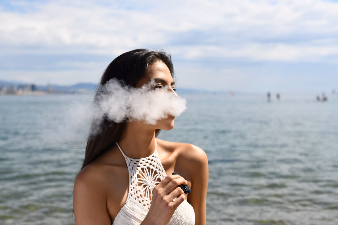 Femme qui fume au bord de mer